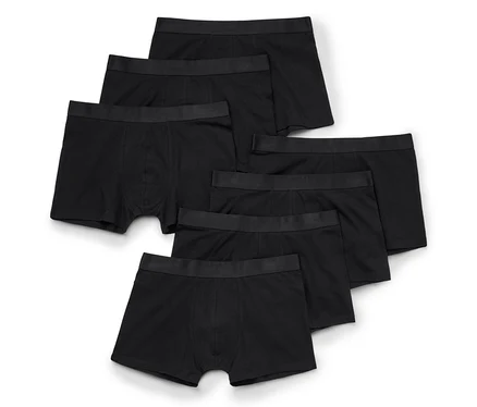 Six boxers noirs avec une ceinture élastique noire, disposés en éventail sur un fond blanc.