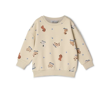 Sweat-shirt enfant crème à manches longues, orné d'un motif de chiens de dessin animé sur des skateboards et de petits points bleus.