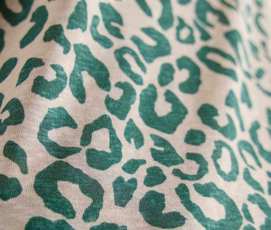 Gros plan d'un t-shirt manches courtes CECIL beige avec un motif léopard vert.