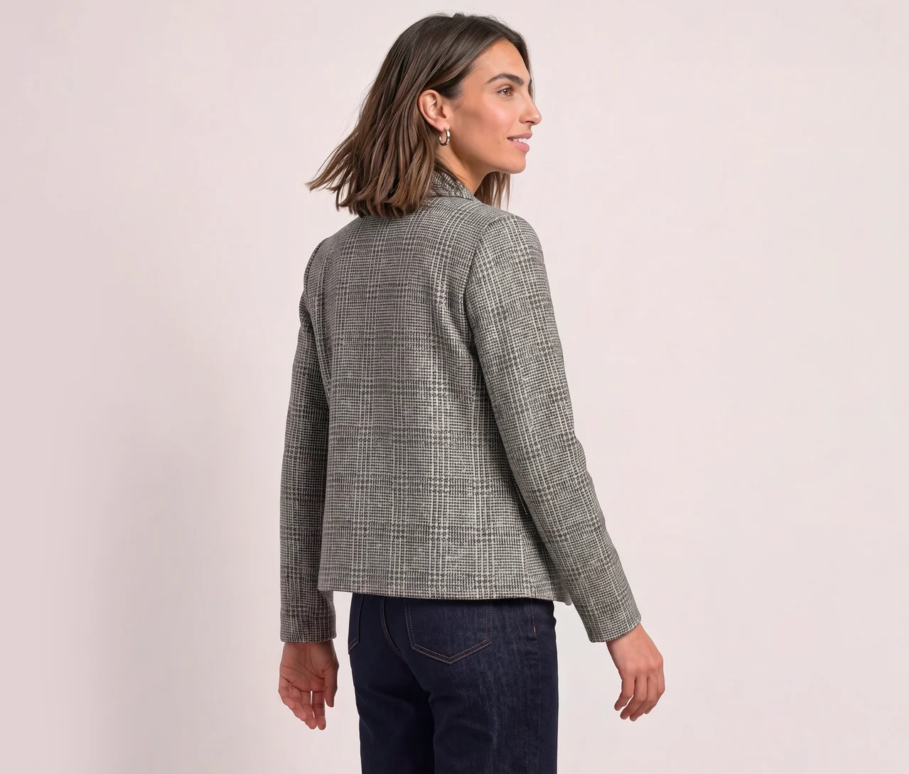 Femme vue de dos, légèrement tournée vers la droite, portant un blazer Street One à carreaux et un jean foncé.