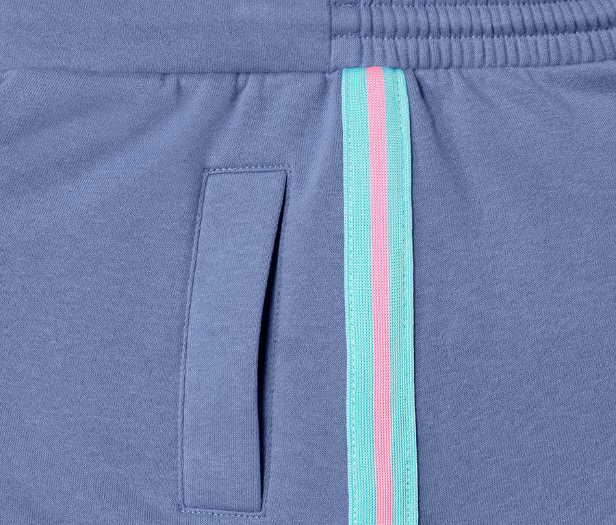 Gros plan sur une jupe molletonnée violette avec une poche et une bande décorative.