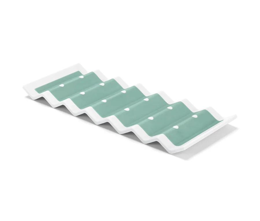 Un support de bouteille pour réfrigérateur blanc avec des creux turquoise.