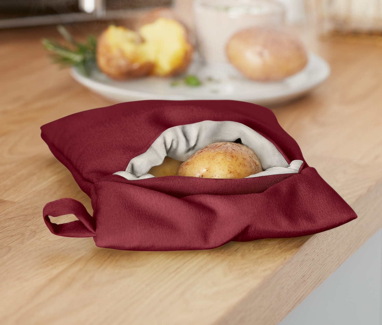 Une pomme de terre dans un sac de cuisson pour pommes de terre au micro-ondes sur un comptoir de cuisine.