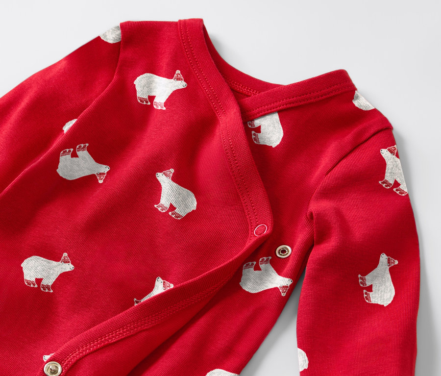 Gros plan de deux bodies enfant à manches longues rouges avec des motifs d'ours polaires.