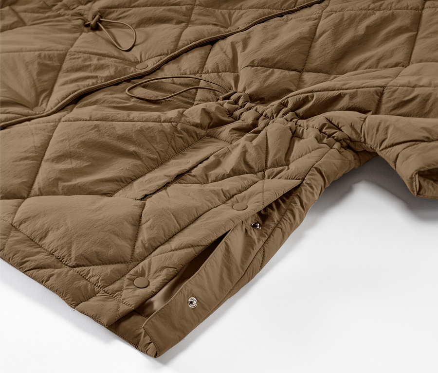 Détail d'un poncho matelassé à capuche marron.