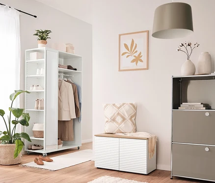 Intérieur avec une garde-robe mobile avec miroir, un banc et un pouf avec espace de rangement et une table d’appoint en métal « CN3 » avec 2 abattants.