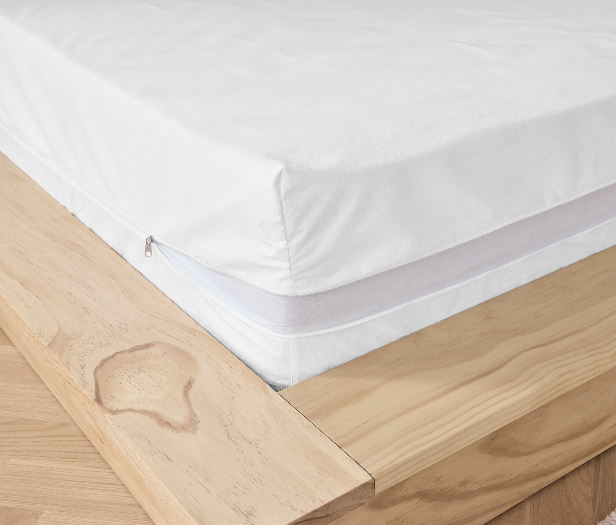 Vue détaillée d'un matelas avec une housse de matelas anti-acariens blanche.