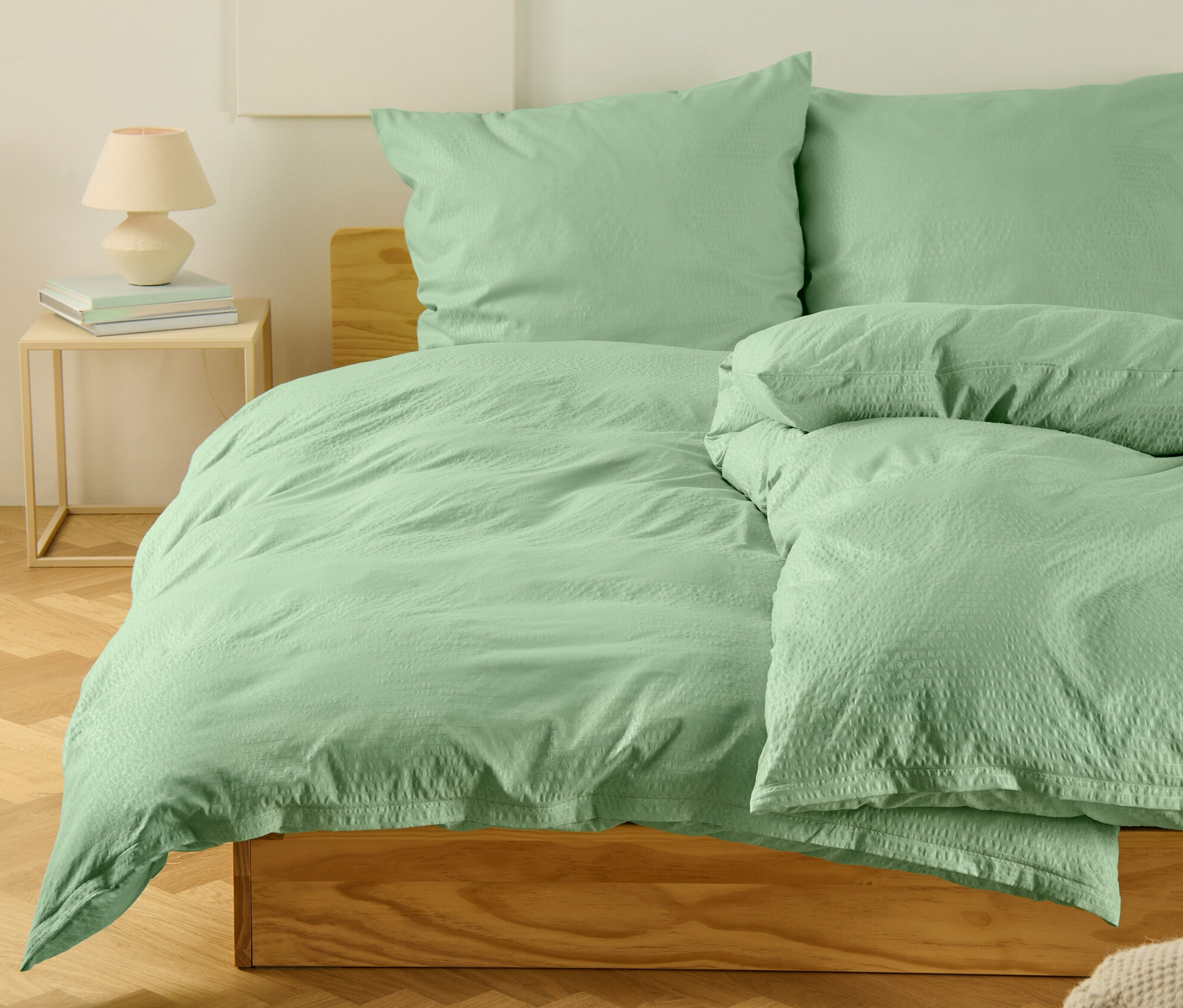 Parure de lit en seersucker verte de taille standard et grande taille sur un lit.