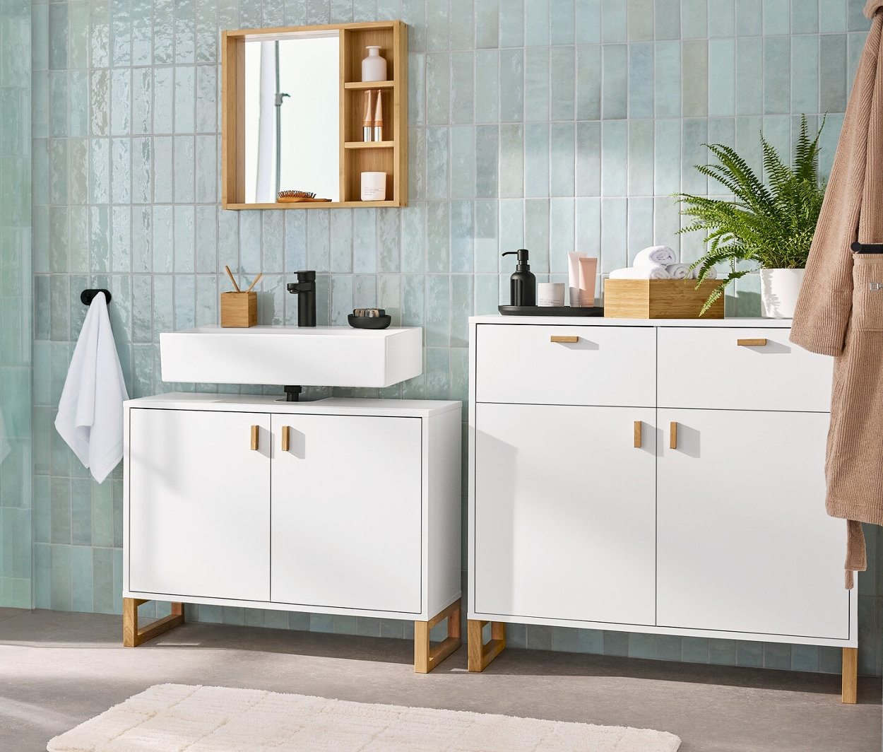 Intérieur de salle de bain avec un meuble sous-lavabo avec 2 portes, un miroir avec des étagères, un buffet avec 2 tiroirs et 2 portes et une armoire haute de salle de bain.