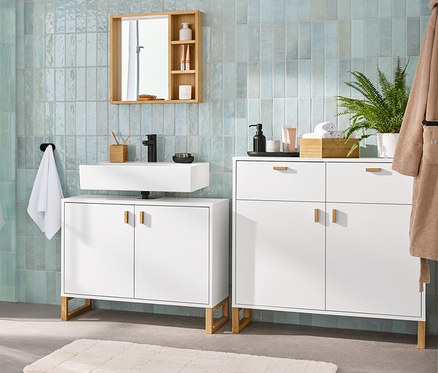 Intérieur de salle de bain avec un meuble sous-lavabo avec 2 portes, un miroir avec des étagères, un buffet avec 2 tiroirs et 2 portes et une armoire haute de salle de bain.