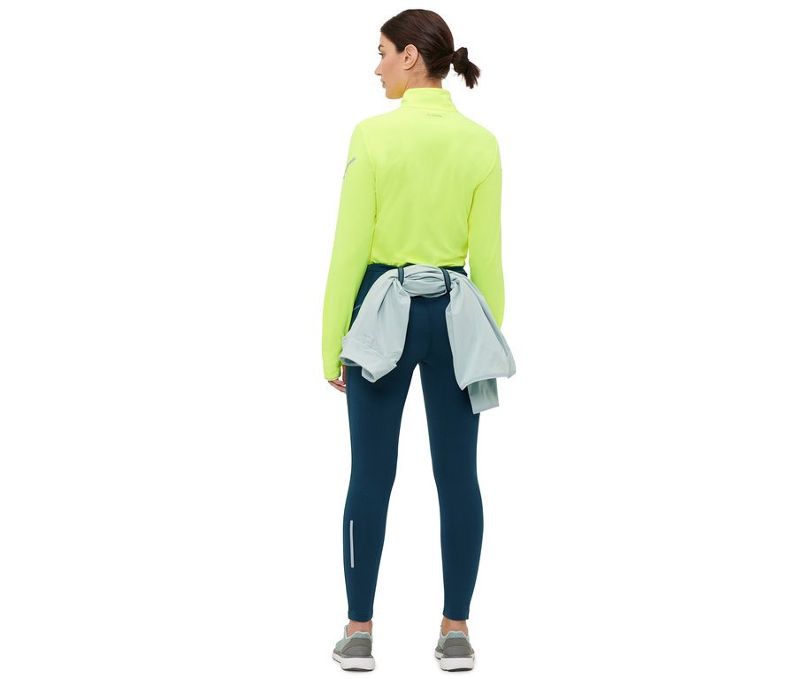 Femme vue de dos portant un legging thermique de course bleu foncé.
