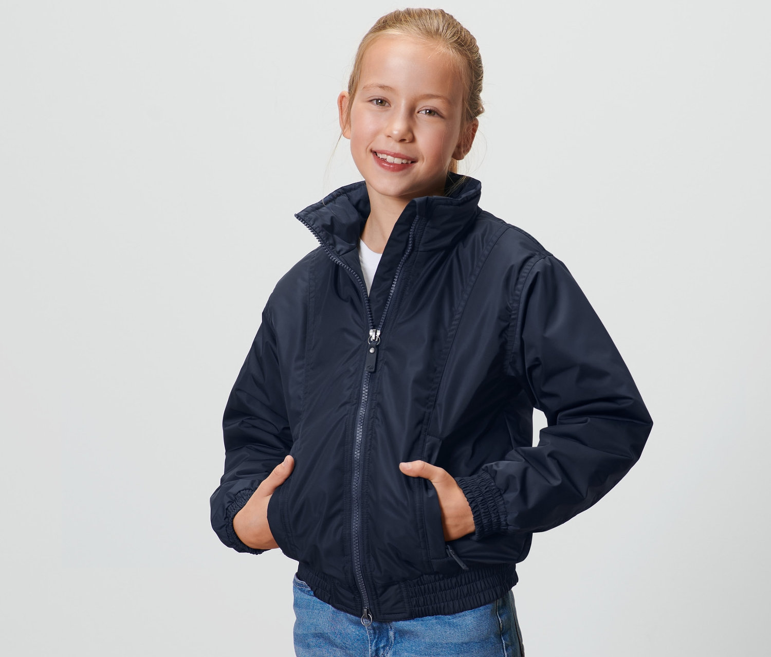 Fille posant en blouson bleu foncé pour enfant.