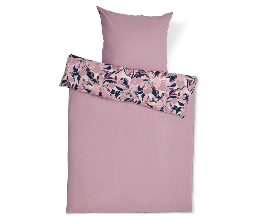 Linge de lit rose avec motif floral sur l'oreiller et une partie de la couette.