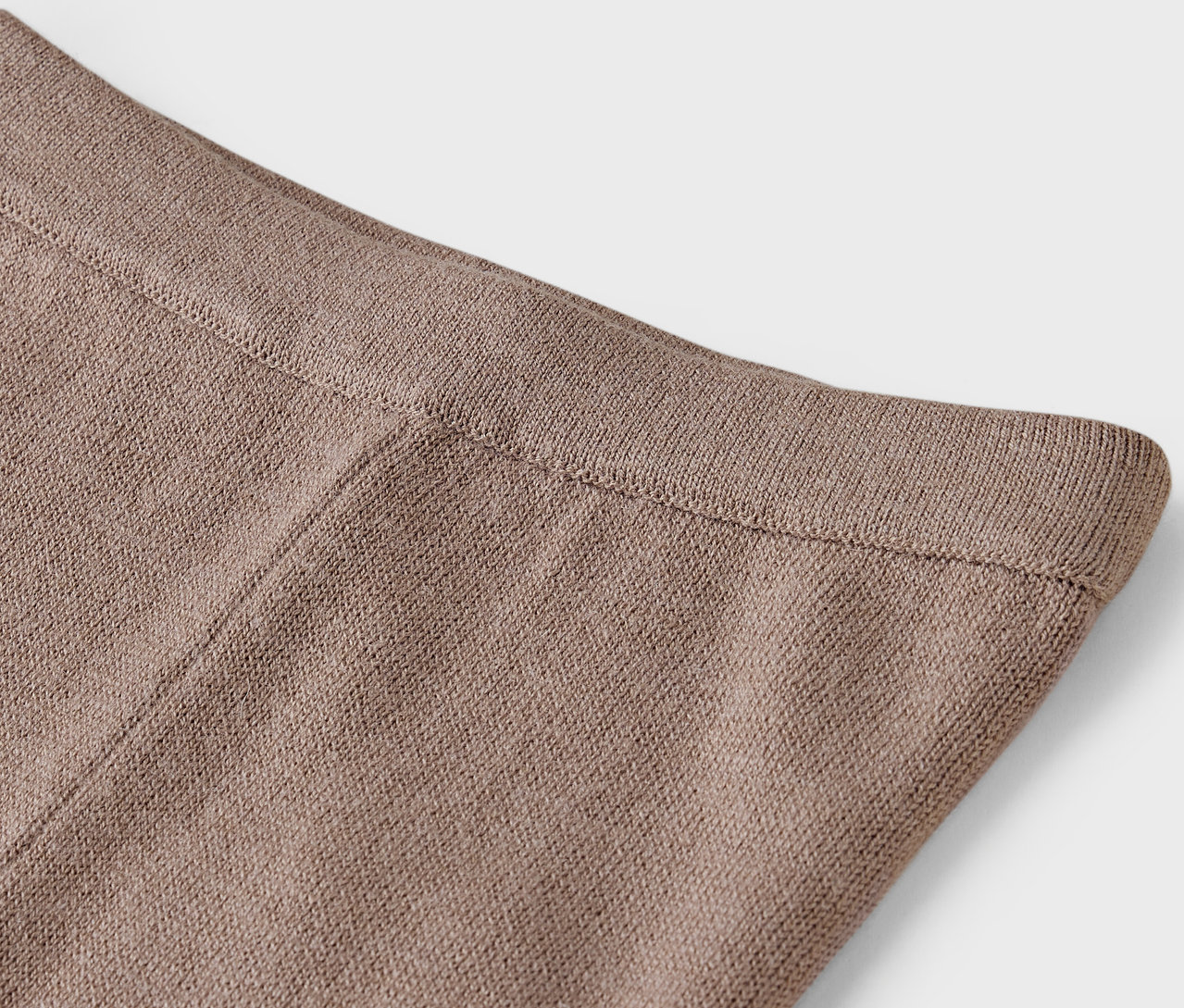 Gros plan sur le haut d'un pantalon tricoté marron.