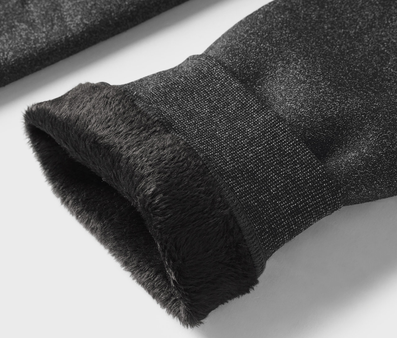 Gros plan sur la manche grise avec une doublure en fourrure noire.