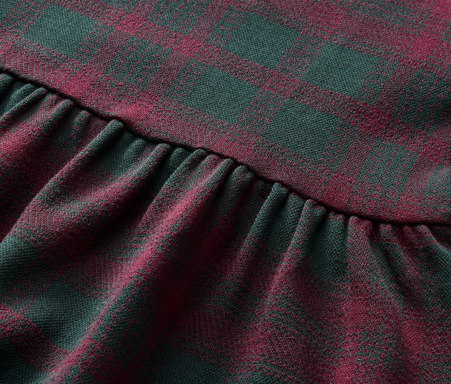 Gros plan sur un tissu à motif carreaux rouge et vert avec des fronces.