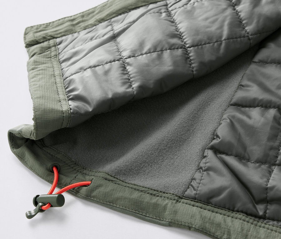 Détail d'un gilet matelassé « pack light » olive avec cordon de serrage orange.