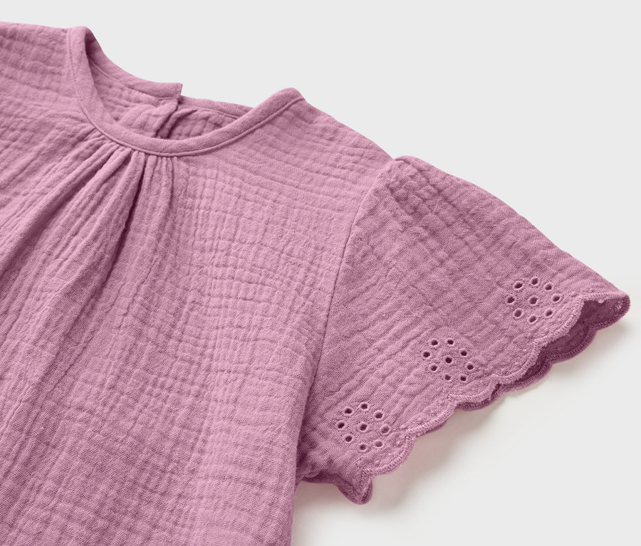 Gros plan sur une blouse en mousseline pour enfant.