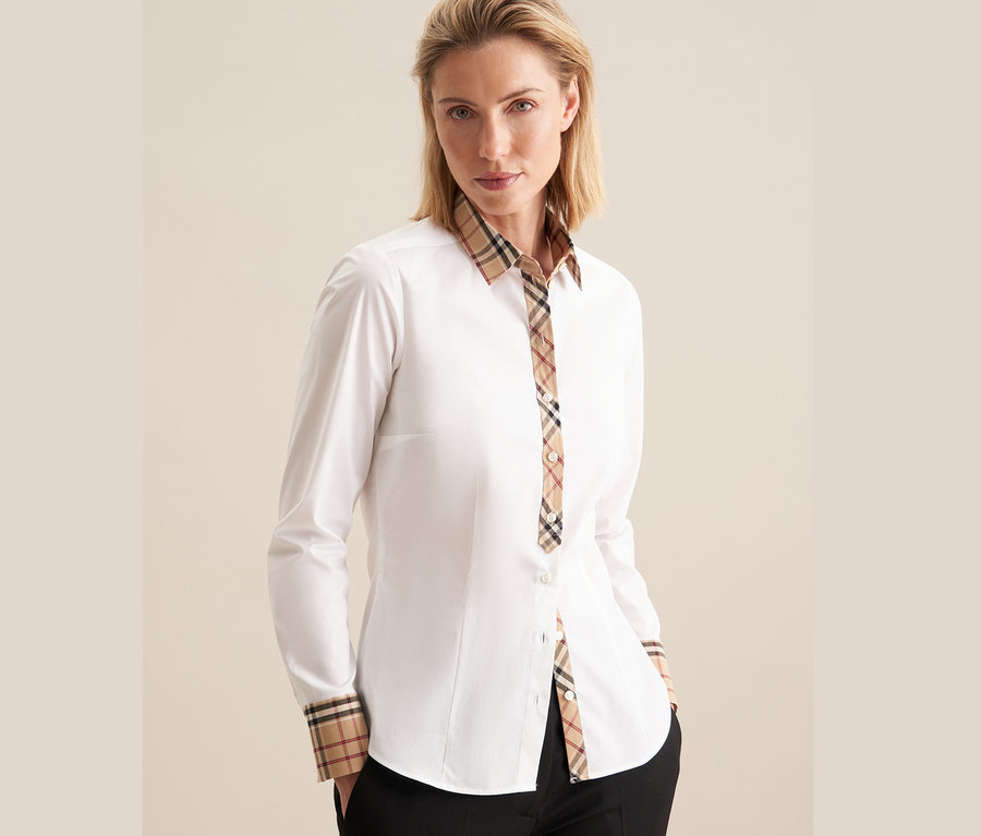 Une femme portant une chemise en popeline blanche à carreaux Seidensticker.