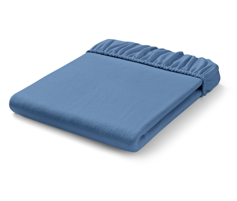 Drap-housse bleu clair plié avec des coins élastiques.