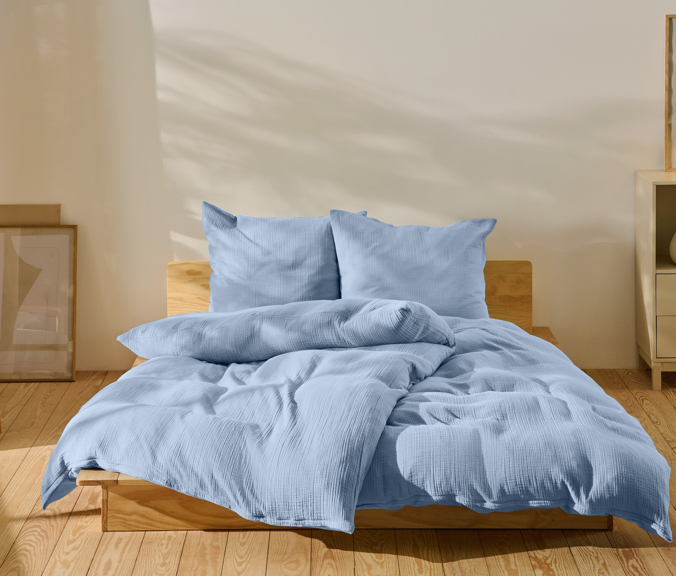 Linge de lit bleu clair sur un lit dans une chambre.