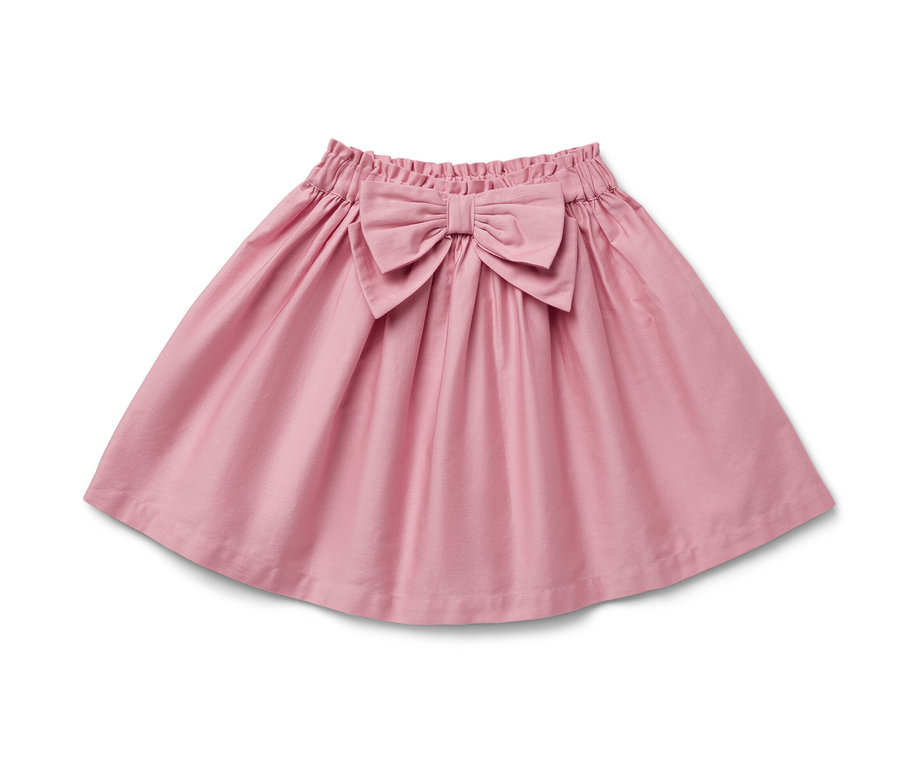 Une jupe tissée rose pour enfant avec un nœud à la taille.