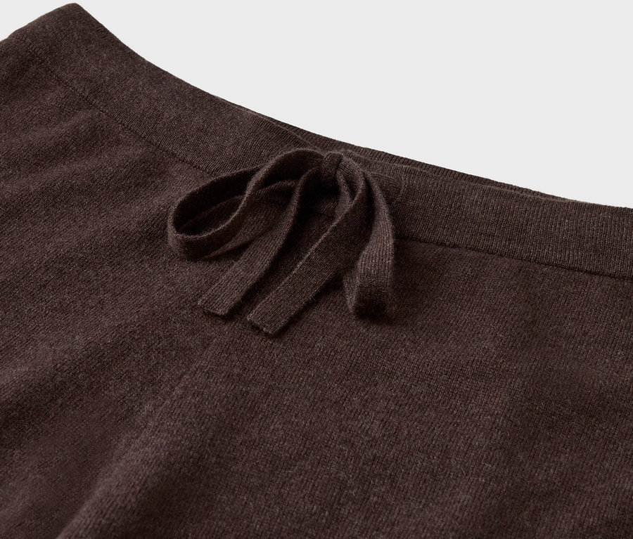 Détail d'un pantalon en tricot marron avec cordon de serrage.