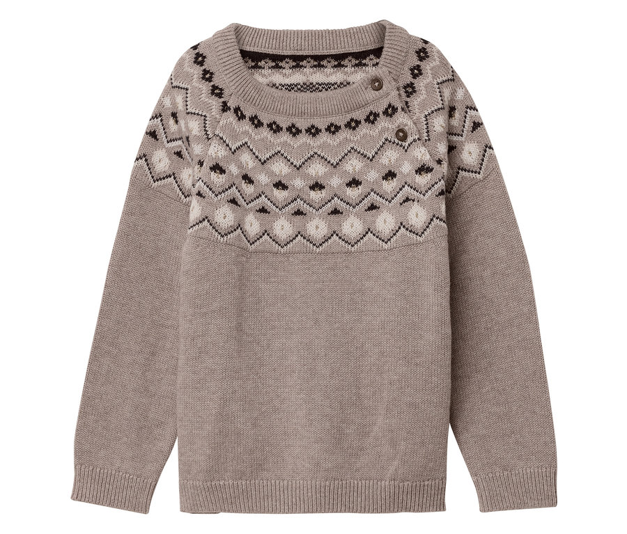 On voit un pull en maille pour enfant beige avec un motif sur le haut.