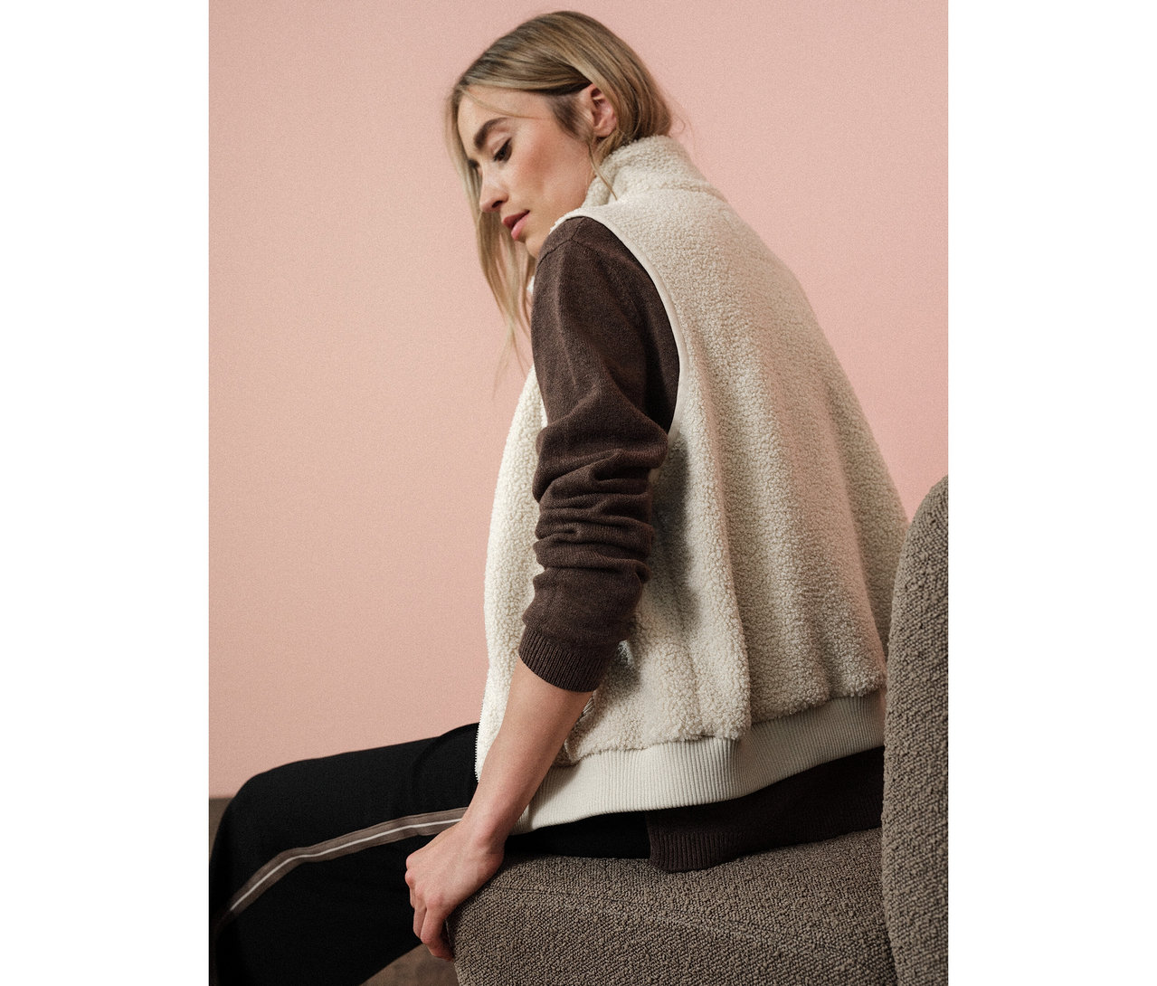 Femme assise portant une veste en teddy Street One sur un pull marron.