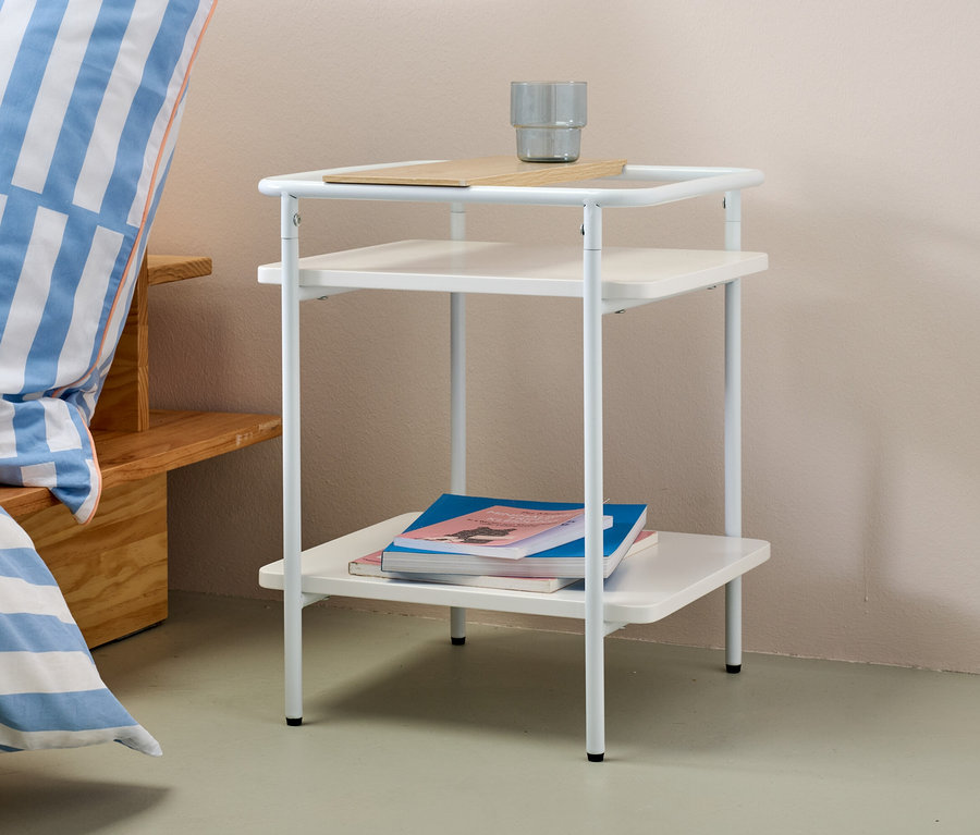 Table d’appoint blanche avec deux étagères et une tasse grise sur le dessus.