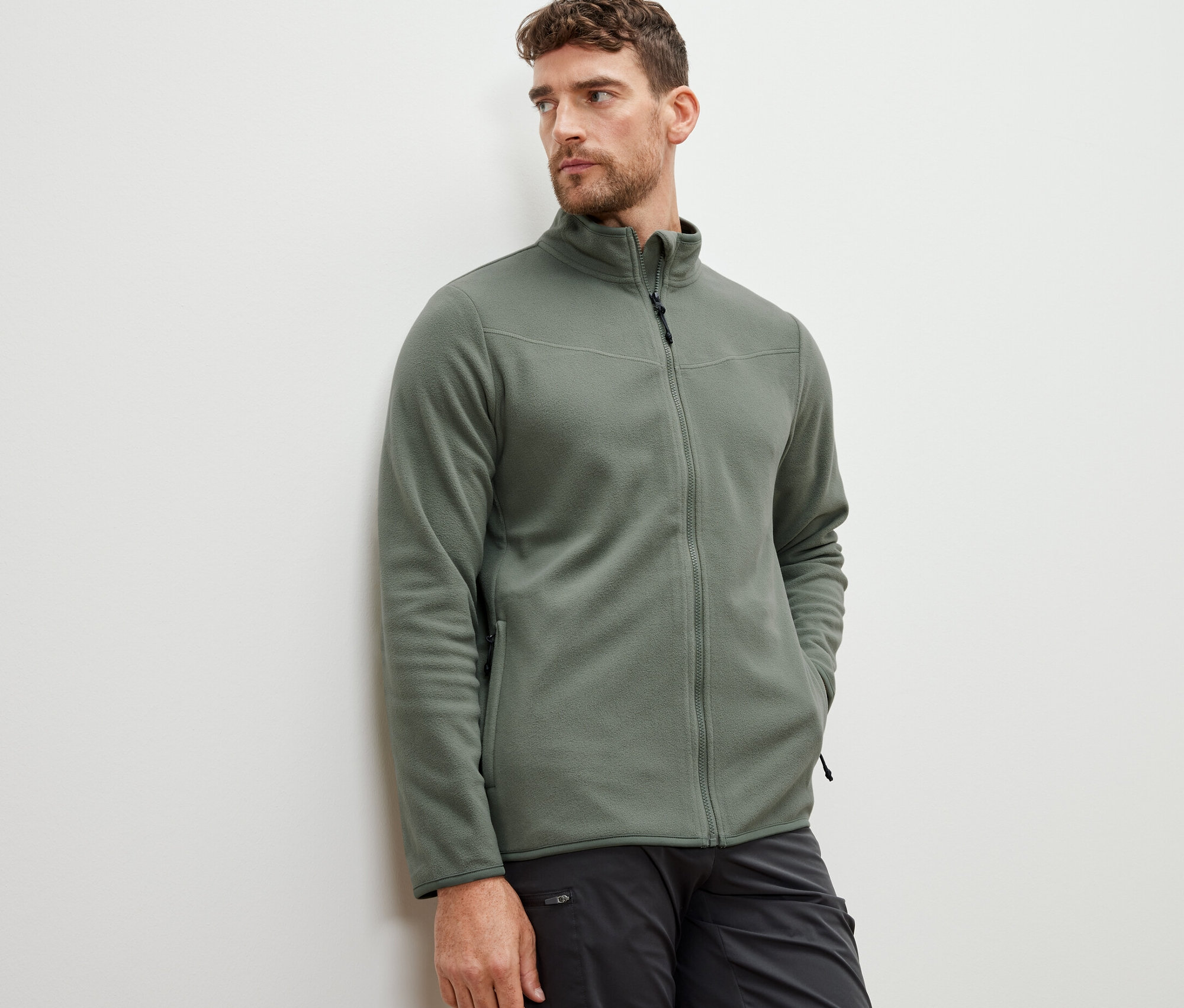 Un homme porte une veste polaire kaki.