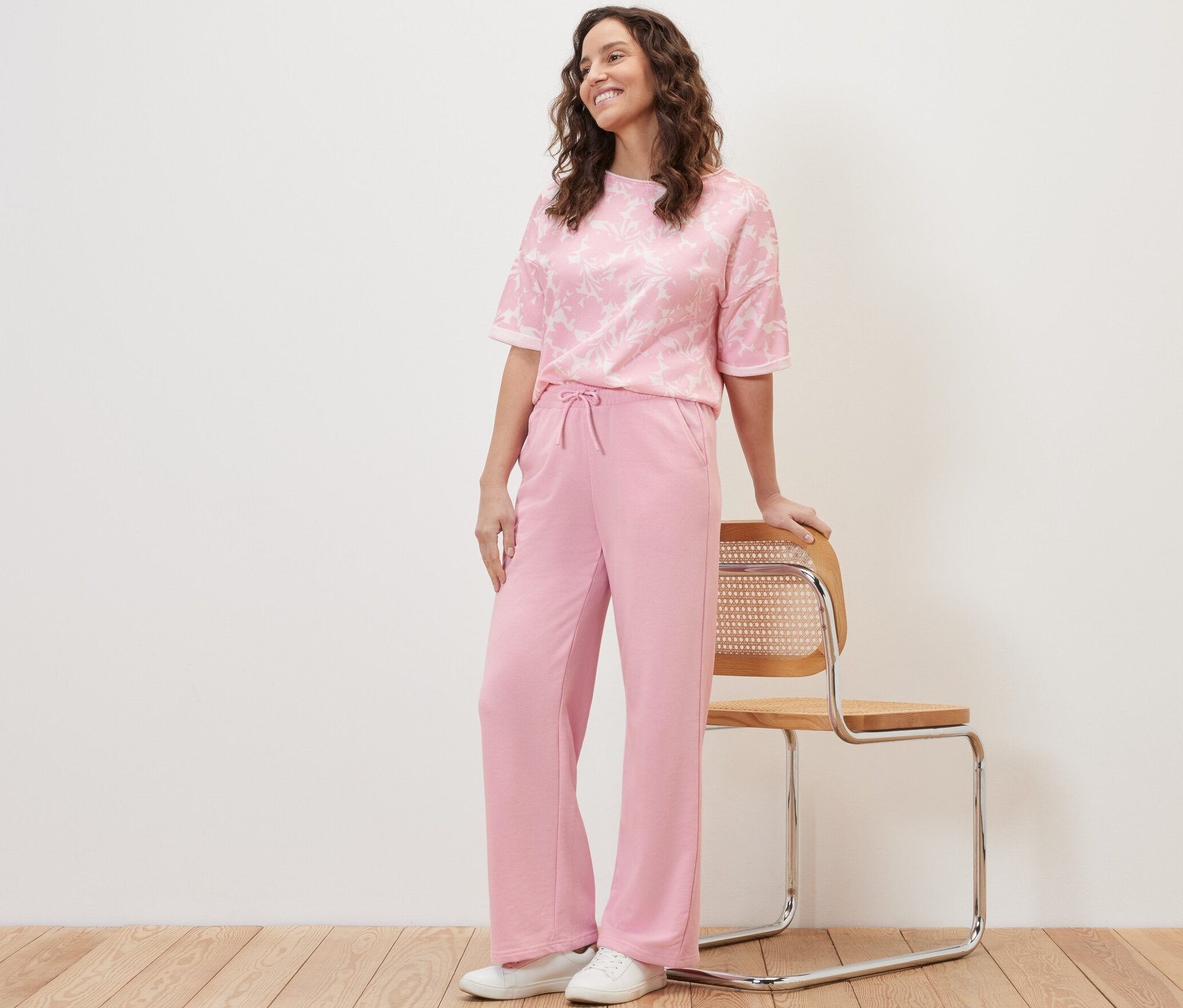 Femme posant en pantalon de jogging rose.