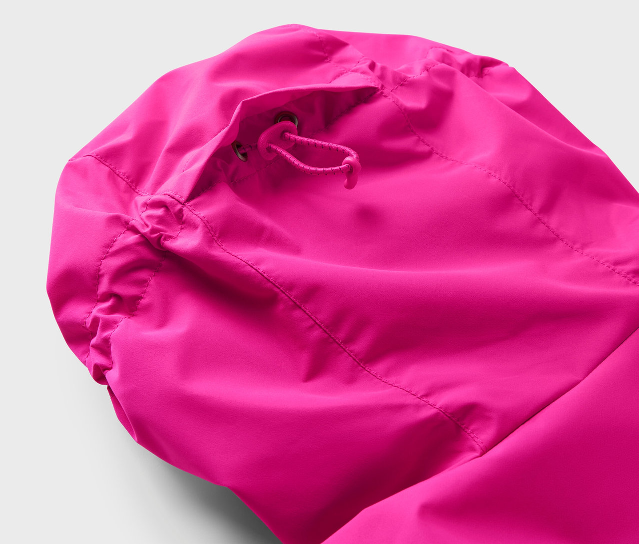 Gros plan de la capuche d'une veste rose avec cordon de serrage.
