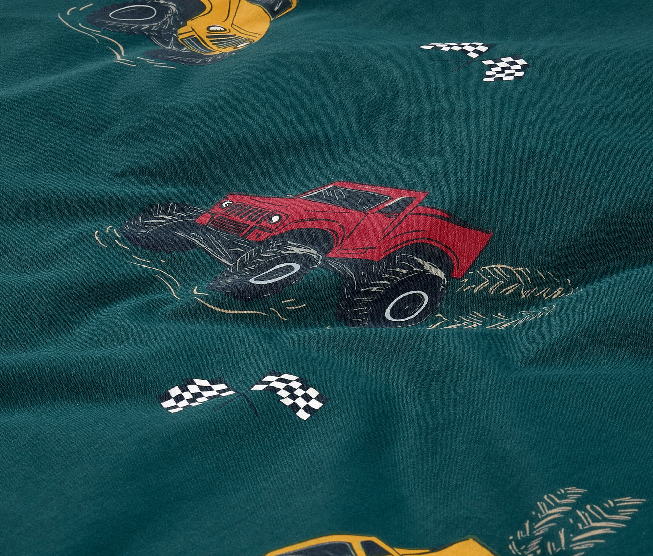 Gros plan sur une parure de lit pour enfant en renforcé avec un motif de camions, taille standard.