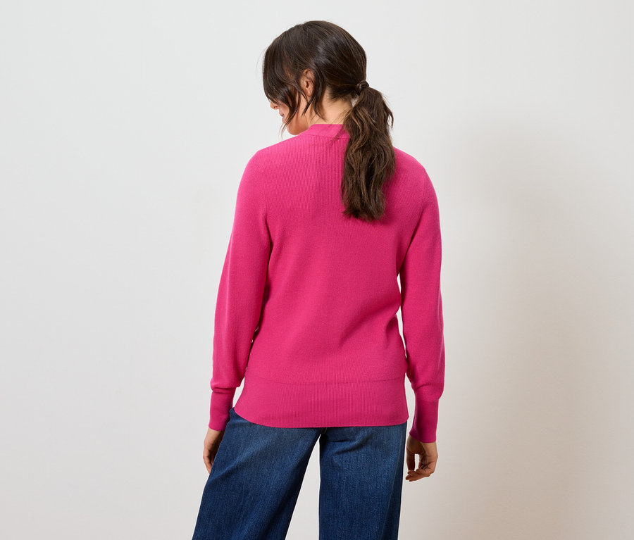 Vue arrière d'une femme portant un pull rose et un jean bleu.
