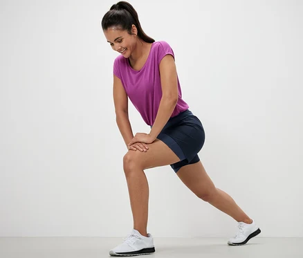 Femme s'étirant en short de sport 2 en 1.