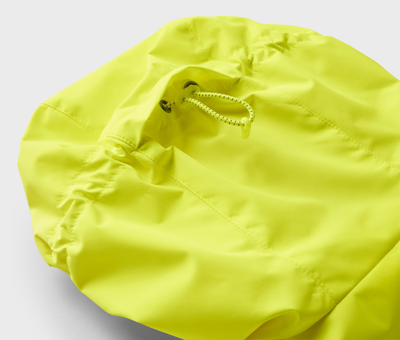 Détail d'une veste jaune avec cordon de serrage.