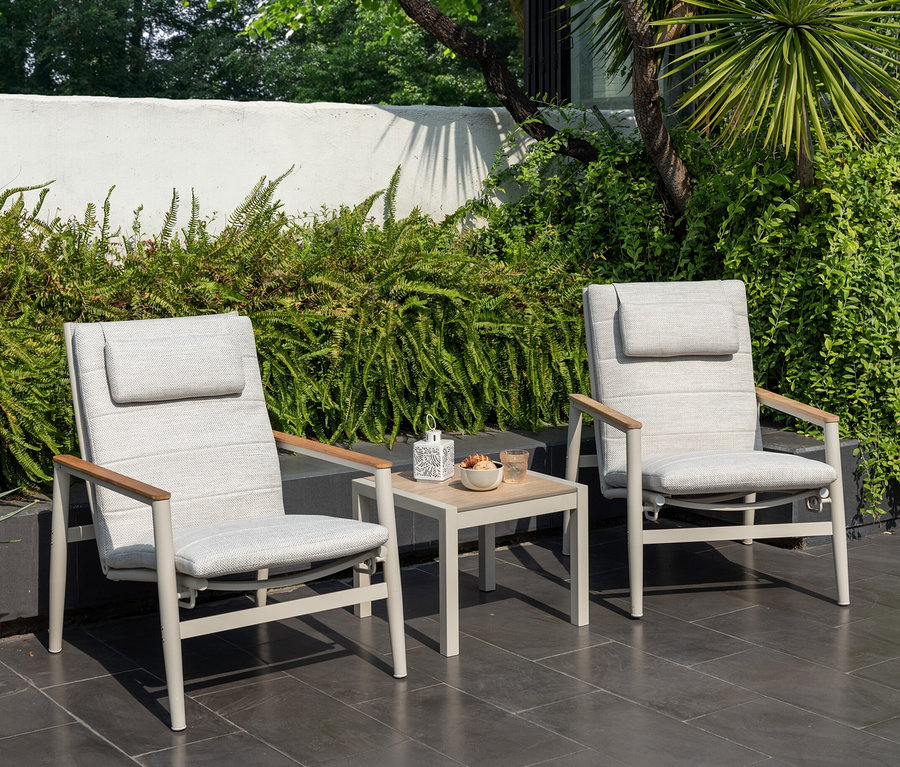 Deux fauteuils de salon d'extérieur ScanCom gris clair avec dossier réglable et une table avec des rafraîchissements sur une terrasse.