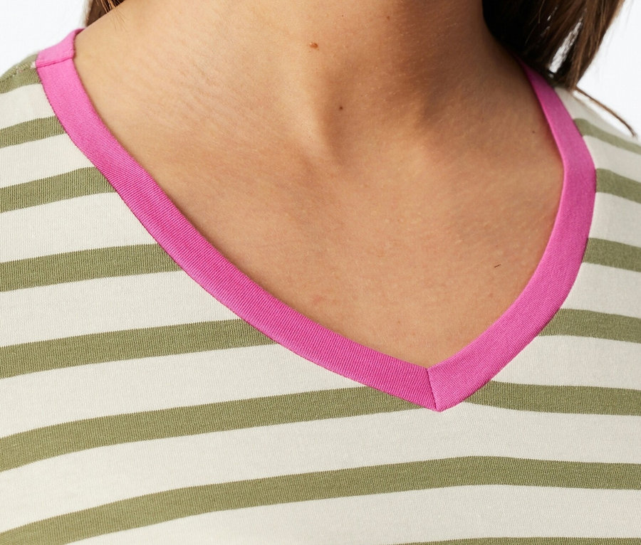 Gros plan d'une femme portant un haut rayé avec un col en V rose.