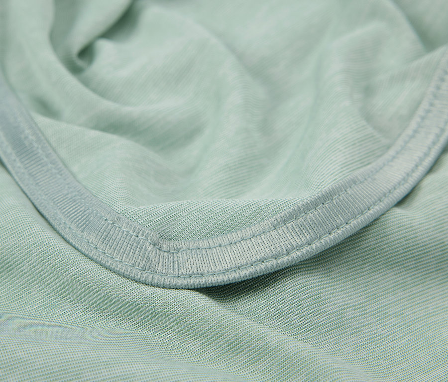 Gros plan d'un tissu vert clair avec ourlet.
