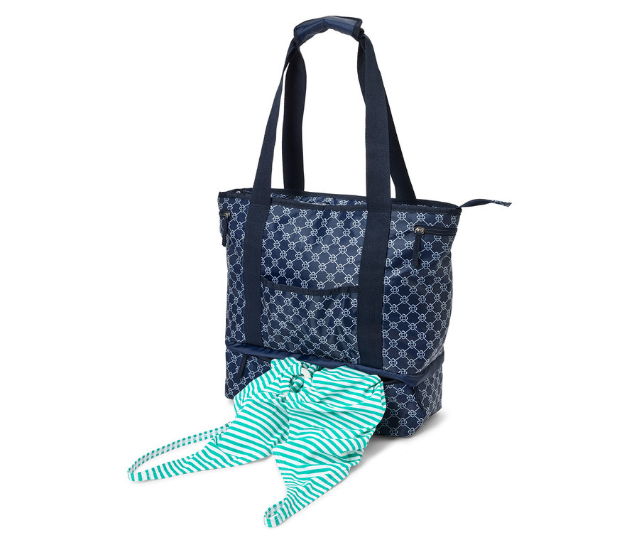 Sac fourre-tout bleu marine avec motif blanc et anses bleu marine. Un vêtement rayé dépasse du compartiment inférieur.