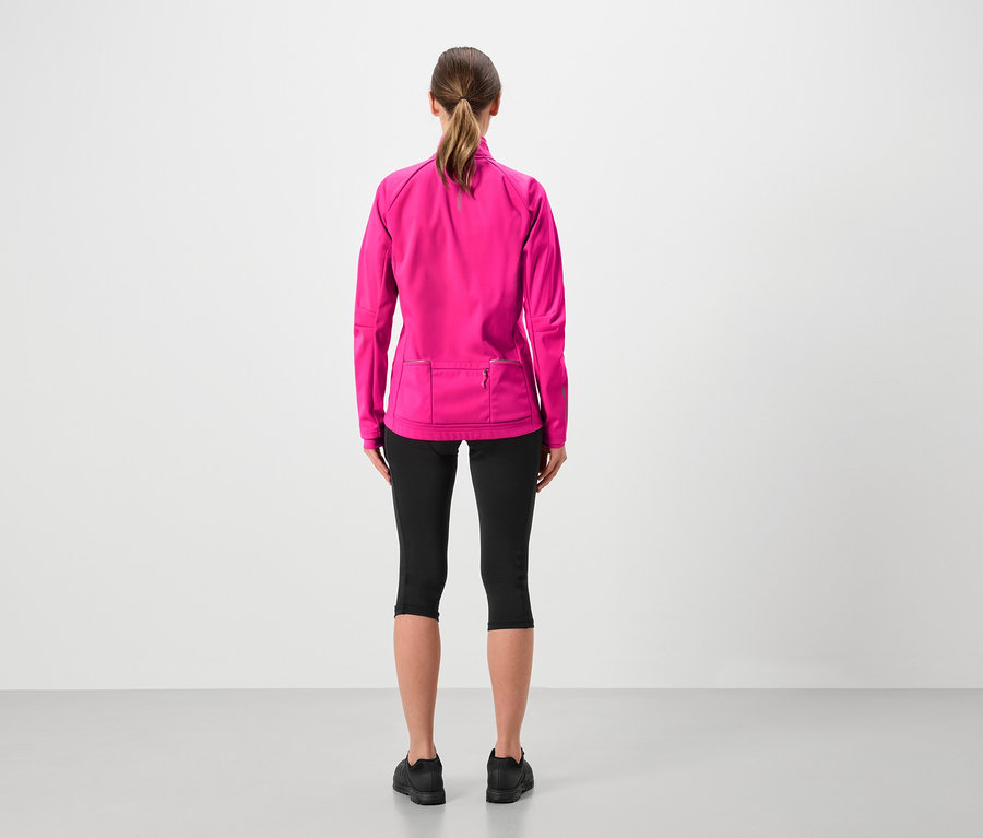 Vue arrière d'une femme avec une queue de cheval portant une veste rose, un legging noir et des chaussures noires.