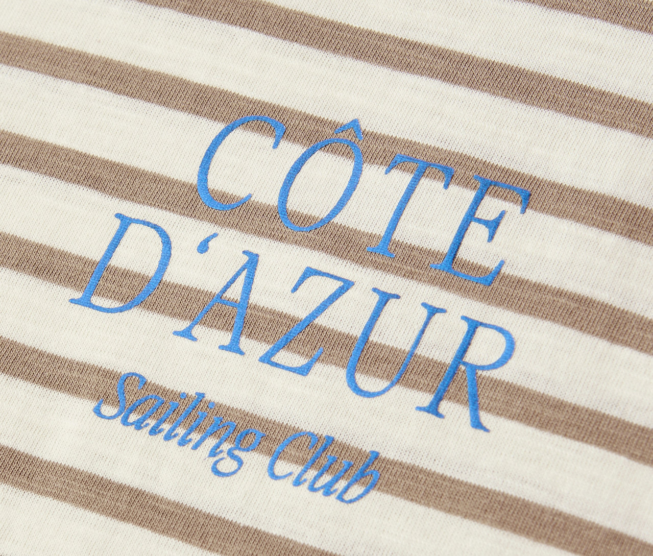Gros plan sur un t-shirt Street One beige et blanc avec l'inscription bleue « Côte d'Azur Sailing Club ».