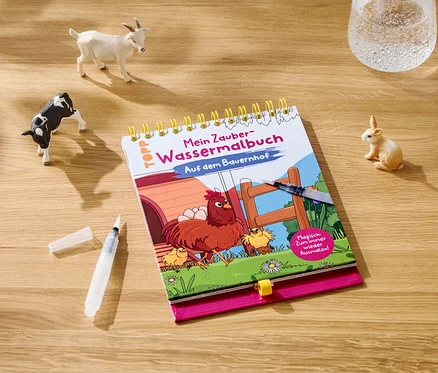 Sur une table en bois se trouvent un livre de coloriage, un pinceau, un verre d'eau et des figurines d'animaux.