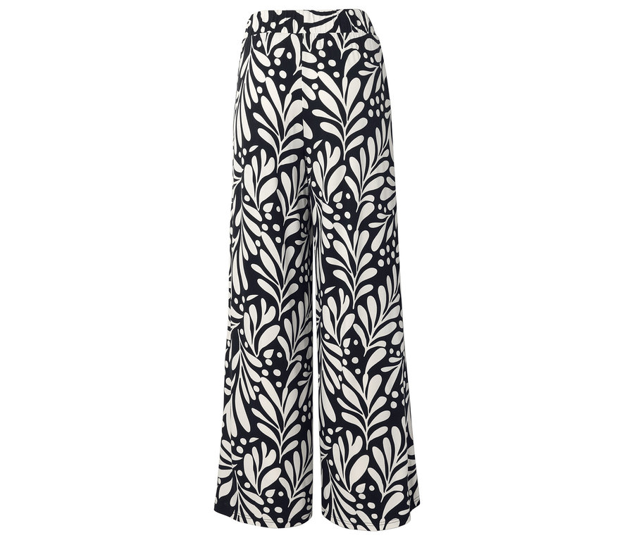 Pantalon noir large avec motif de feuilles et de points blancs.