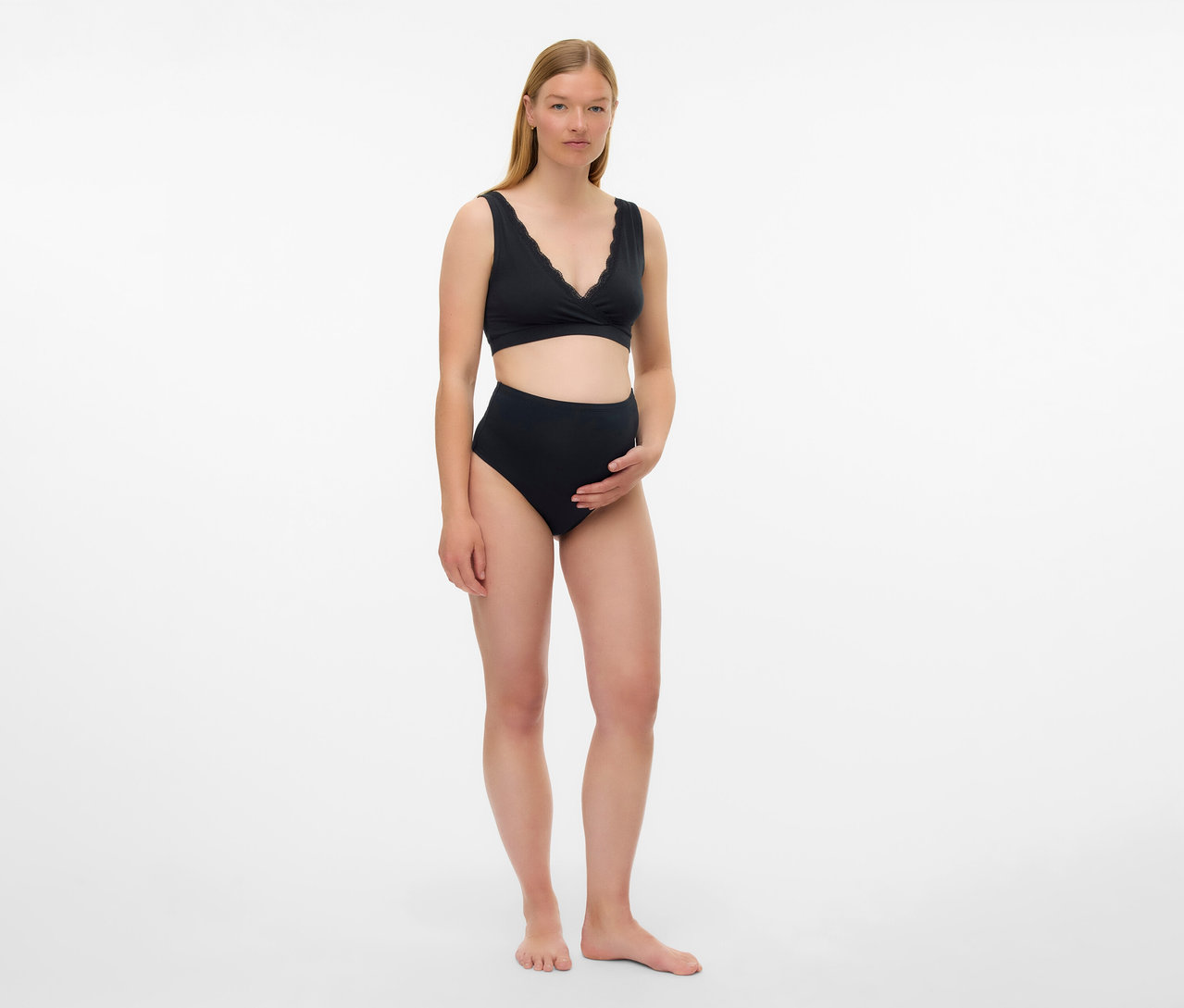 Une femme enceinte porte un lot de 2 soutiens-gorge de grossesse et d’allaitement noirs MAMALICIOUS « MLHELENA » et une culotte taille haute sur fond blanc.
