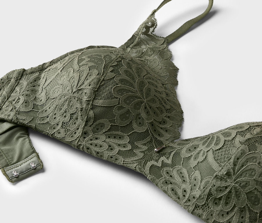 Gros plan d'un soutien-gorge en dentelle verte sur fond blanc.