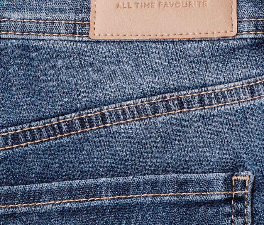 Gros plan sur un jean 7/8 Street One « Jane » bleu avec une étiquette de marque beige et des surpiqûres contrastantes.