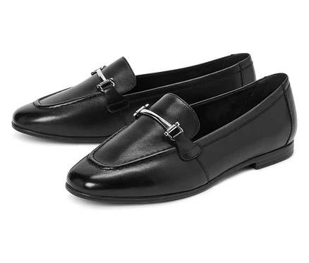 Deux mocassins noirs avec des boucles argentées sont placés côte à côte.