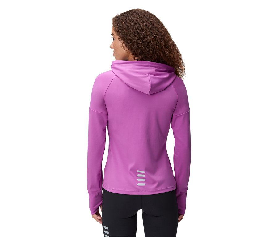 Vue arrière d'une femme aux cheveux bouclés portant un sweat à capuche violet et un legging noir.